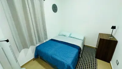 a small bedroom with a bed with blue sheets at Casa de Sasha