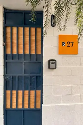 a blue door with a sign on the side of a building at Casa Maruca- 2 bedrooms Home for 5 Guests - A charming getaway near downtown & financial hub area! in San Salvador