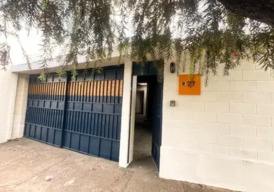 a building with a blue garage door and a tree at Casa Maruca- 2 bedrooms Home for 5 Guests - A charming getaway near downtown & financial hub area! in San Salvador