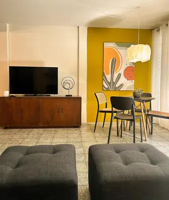 a living room with a television and a table and chairs at Casa Maruca- 2 bedrooms Home for 5 Guests - A charming getaway near downtown & financial hub area! in San Salvador