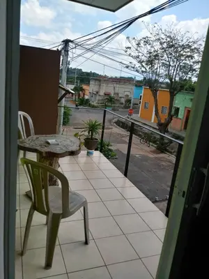 a table and chair on a balcony with a view of a street at Casa Blanca Tu Casa in Santa Ana
