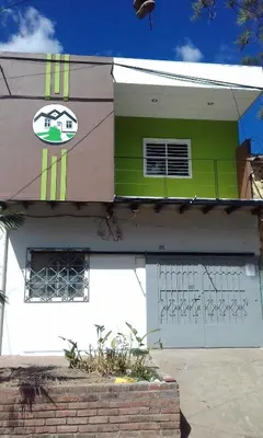 a green and white building with a garage at Casa Blanca Tu Casa in Santa Ana