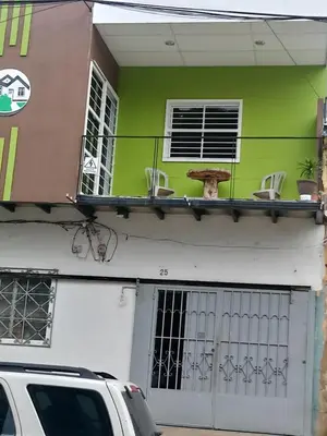 a green building with a balcony with chairs on it at Casa Blanca Tu Casa in Santa Ana