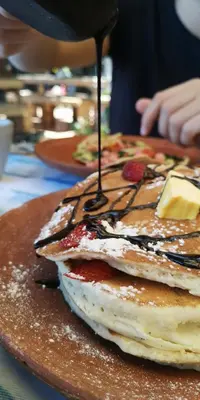 a stack of pancakes are being drizzled with sauce at Casa 1800 Suchitoto Boutique in Suchitoto