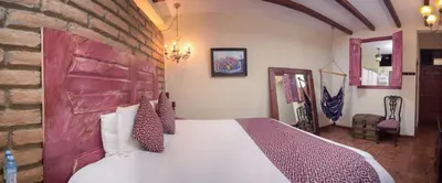 a bedroom with a bed and a brick wall at Casa 1800 Suchitoto Boutique in Suchitoto