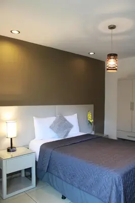 a bedroom with a large bed with a blue blanket at Terra Bella Hotel Boutique in San Salvador