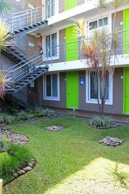 a building with green doors and a grass yard at Terra Bella Hotel Boutique in San Salvador