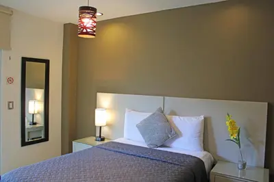 a bedroom with a bed and two lamps and a mirror at Terra Bella Hotel Boutique in San Salvador