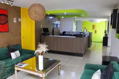 a lobby with green couches and a table and a counter at Terra Bella Hotel Boutique in San Salvador