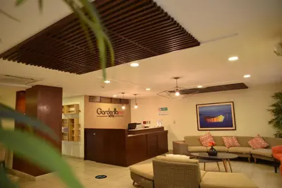 a lobby with a waiting room with couches and a table at Hotel Gardenia Inn in San Salvador