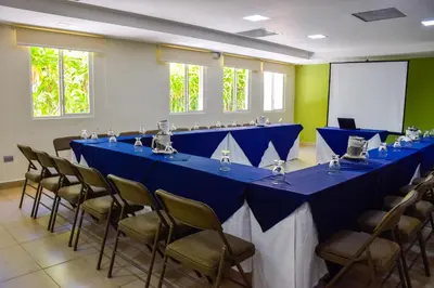 a row of blue tables and chairs in a room at Hotel Gardenia Inn in San Salvador