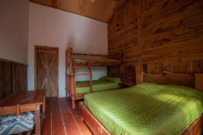 a bedroom with two bunk beds and a table at Villa Verde in Perquín