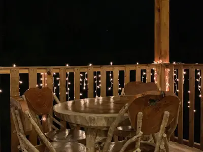 a wooden table and chairs on a deck with lights at Villa Verde in Perquín