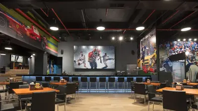 a dining room with tables and a large screen at Barceló San Salvador in San Salvador