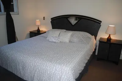 a bedroom with a large bed with white sheets and two lamps at Apart Hotel Valle Verde PLANES DE RENDEROS in San Salvador