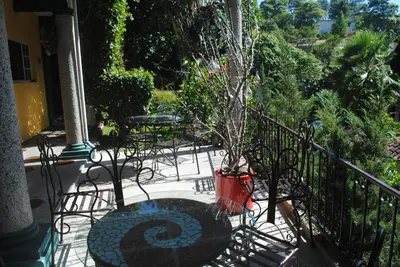 a potted tree sitting on a balcony at Apart Hotel Valle Verde PLANES DE RENDEROS in San Salvador