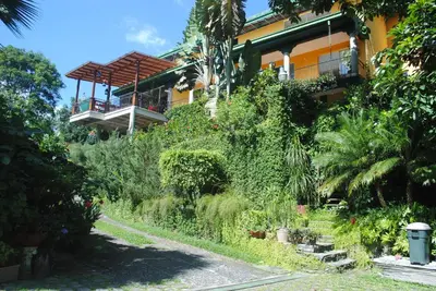 a building with a balcony on the side of it at Apart Hotel Valle Verde PLANES DE RENDEROS in San Salvador