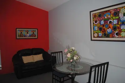 a living room with a table and a couch at Apart Hotel Valle Verde PLANES DE RENDEROS in San Salvador