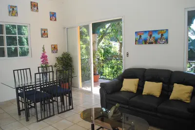 a living room with a black couch and a glass table at Apart Hotel Valle Verde PLANES DE RENDEROS in San Salvador