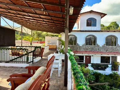 a patio with tables and chairs and a building at Hotel & Restaurant Fleur de Lis in Concepción de Ataco