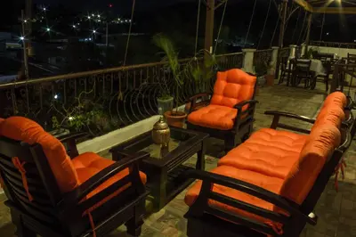a group of chairs and tables on a patio at night at Hotel & Restaurant Fleur de Lis in Concepción de Ataco