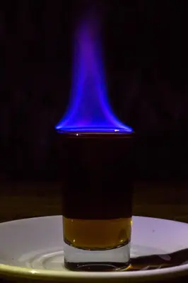 a glass of liquid with a blue top on a plate at Hotel & Restaurant Fleur de Lis in Concepción de Ataco