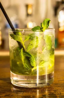 a glass of iced tea with mint on a table at Hotel & Restaurant Fleur de Lis in Concepción de Ataco