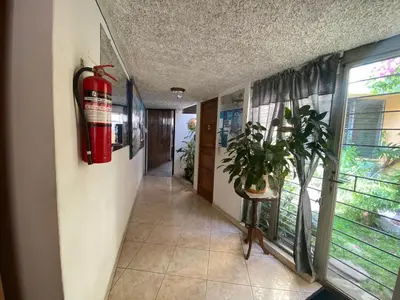 a hallway with a fire extinguisher and a plant in it at Hostal Cumbres de El Salvador in San Salvador