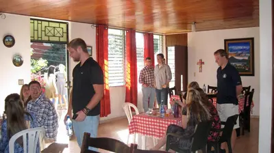 a group of people standing around a table in a room at Hostal Cumbres de El Salvador in San Salvador
