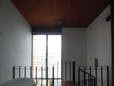 a room with a large window and a wooden ceiling at Hostal Cumbres de El Salvador in San Salvador