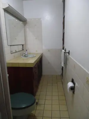 a bathroom with a toilet and a sink and a mirror at Hostal Cumbres de El Salvador in San Salvador