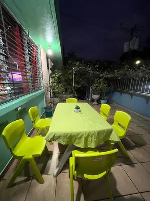 a table and chairs on a patio at night at Hostal Cumbres de El Salvador in San Salvador
