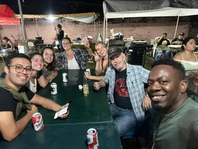 a group of people sitting at a table with drinks at Hostal Cumbres del Volcan Flor Blanca in San Salvador