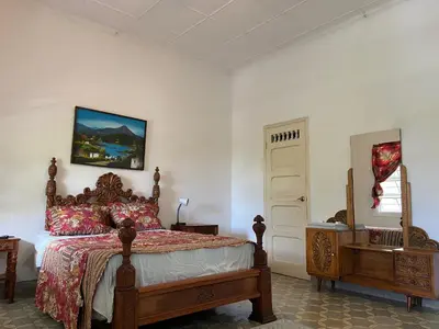 a bedroom with a bed and a window and a door at Hostal Cumbres del Volcan Flor Blanca in San Salvador