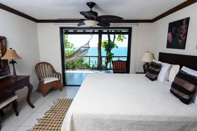 a bedroom with a bed and a view of the ocean at Paraiso Escondido Hotel Villas & Resort in El Níspero