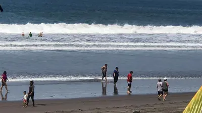 a group of people walking on the beach at Coco Blue a New Beach Resort in La Libertad