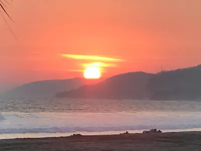 a sunset on the beach with the sun setting at Coco Blue a New Beach Resort in La Libertad