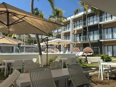 an outdoor patio with tables and chairs and umbrellas at Coco Blue a New Beach Resort in La Libertad