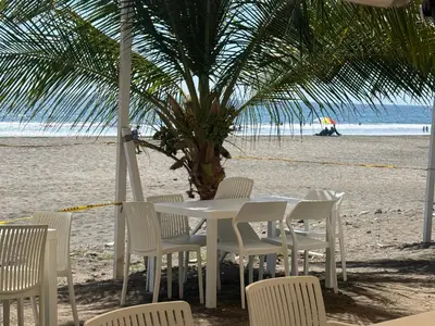 a white table and chairs on the beach at Coco Blue a New Beach Resort in La Libertad