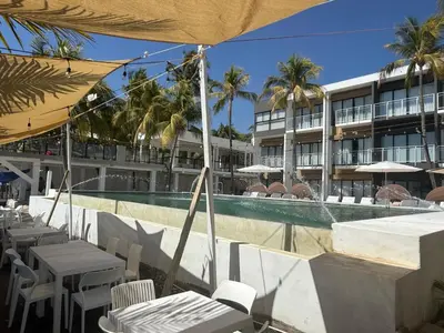 a resort with a swimming pool and tables and umbrellas at Coco Blue a New Beach Resort in La Libertad