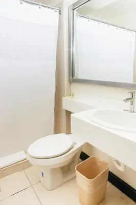a bathroom with a toilet and a sink at Plaza Hotel and Suites in San Salvador
