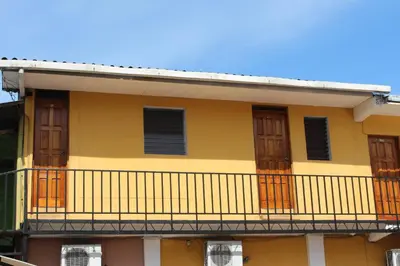 a yellow building with a balcony at Hotel Pasadena II in San Salvador