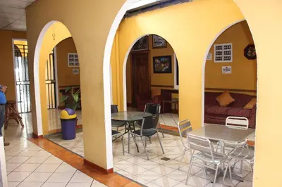 a room with three arches with a table and chairs at Hotel Pasadena II in San Salvador