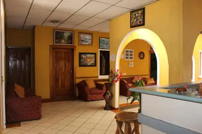 a living room with yellow walls and an archway at Hotel Pasadena II in San Salvador