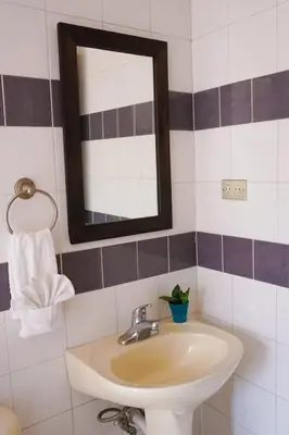 a bathroom with a sink and a mirror at Cinco Hotel B&B in San Salvador