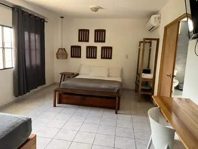 a bedroom with a bed and a table in it at Cinco Hotel B&B in San Salvador