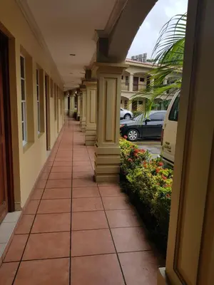 a hallway of a building with columns and flowers at Hotel Florencia in San Miguel