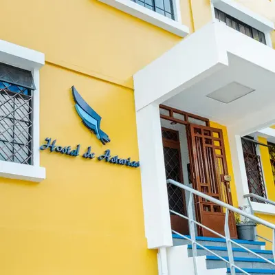 a yellow building with a sign that reads hazard be alarmed at Hostal de Asturias in San Salvador