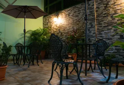 a group of chairs and an umbrella on a patio at Hostal de Asturias in San Salvador