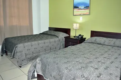a hotel room with two beds and a lamp at Hostal de Asturias in San Salvador